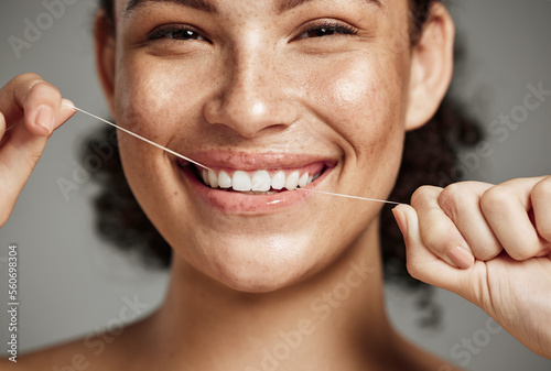 Woman portrait  dental floss and flossing teeth with smile for oral hygiene  health and wellness on studio background. Face of female happy about self care  healthcare and grooming for healthy mouth