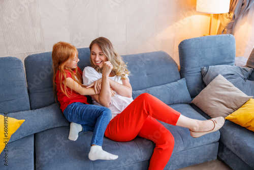 Φωτογραφία Mother and daughter tickling and laughing at home