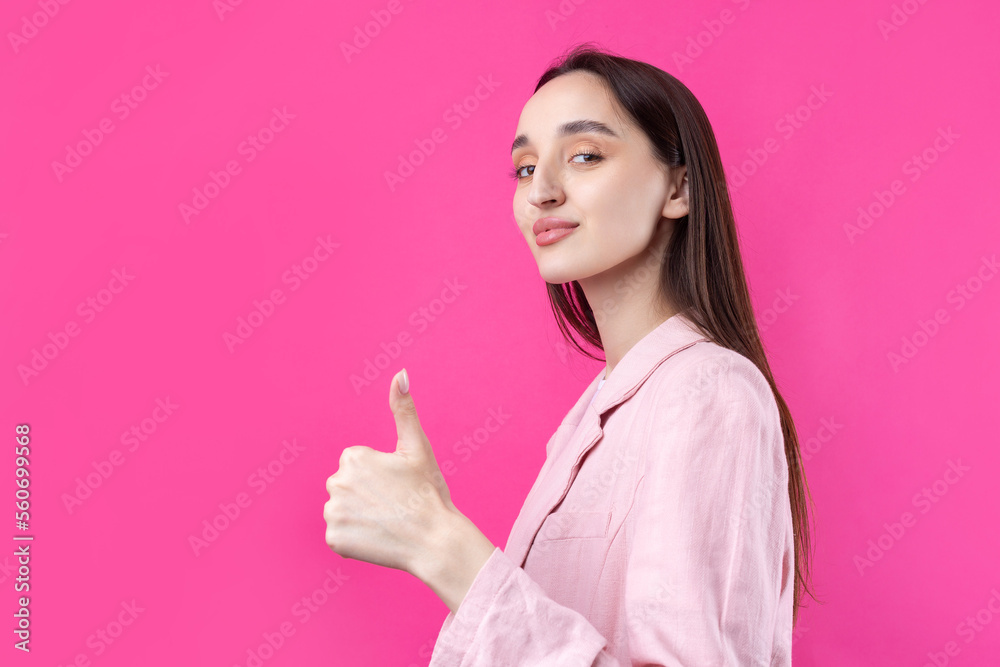 Happy young caucasian female in an pink jacket making thumb up sign and smiling. Good job and respect. Happy young caucasian female in an pink jacket making thumb up sign and smiling. Good job and respect.