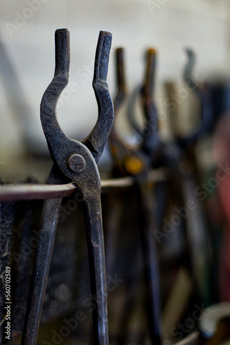 Farrier tools hanging on a concrete block wall photo