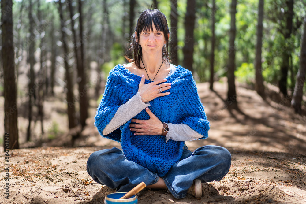 Obraz premium A smiling woman doing breathing exercises while looking at camera.