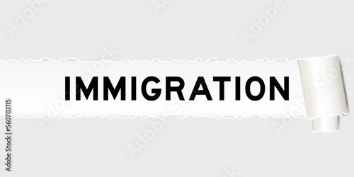 Ripped gray paper background that have word immigration under torn part