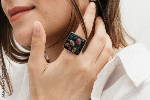 woman wearing floral epoxy earrings and ring photo