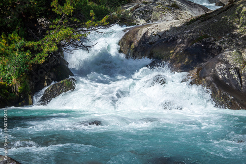 Waterfall in the mountains. A fast mountain river with clear blue water. Lake Darashkol, Belukha national park, Altai republic, Siberia, Russia.