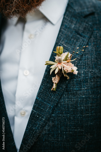 Boutonniere with fresh and dried flowers on grooms suit photo
