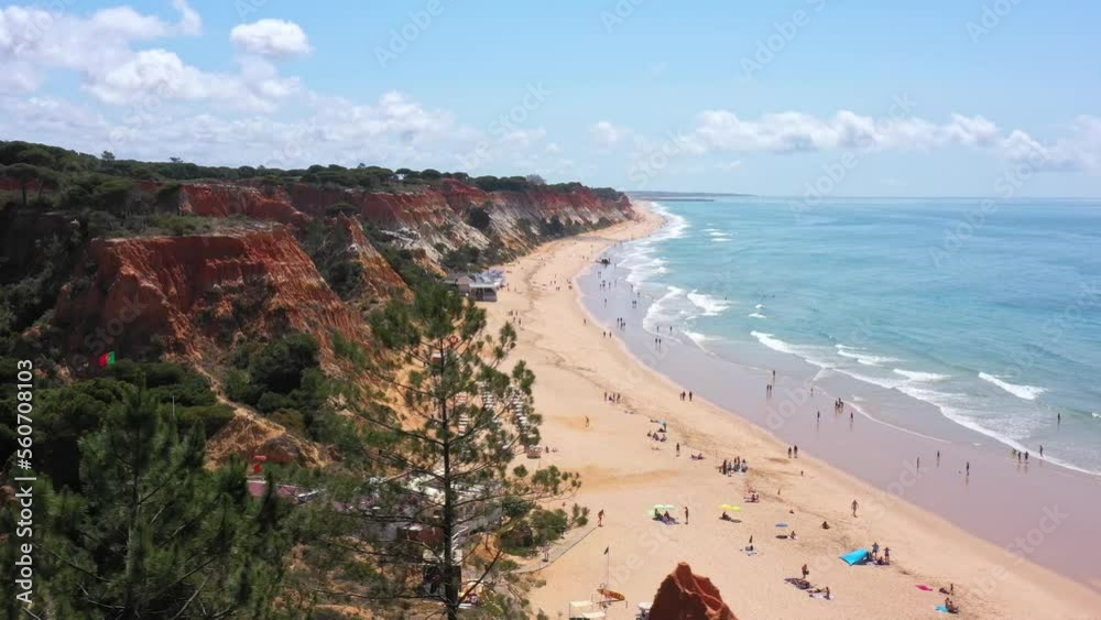Amazing aerial sea view of Portuguese beaches with vacationing tourists and nature. Falesia beach. Drone camera movement, side right.