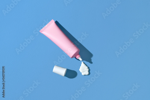 Face cream tube and stroke on blue background