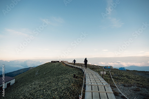 Silhouette of unrecognizable traveler on wooden path photo