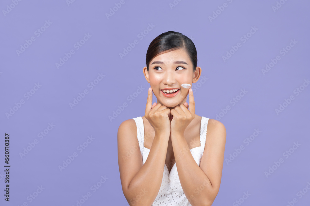 young woman applying moisturizer cream on her pretty face young woman applying moisturizer cream on her pretty face