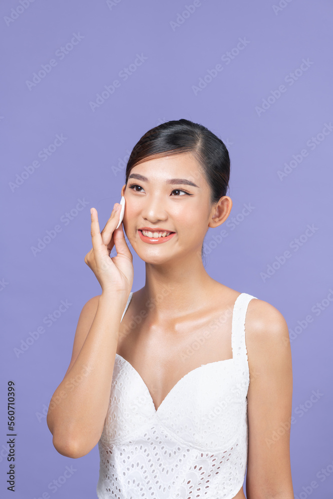 Beautiful young woman cleaning her face with cotton pad Beautiful young woman cleaning her face with cotton pad