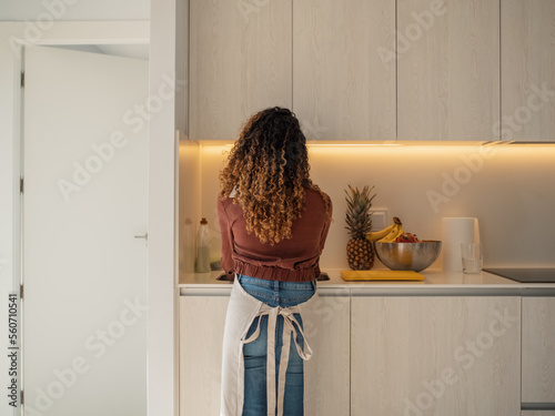 Unrecognizable housewife washing dishes in kitchen photo