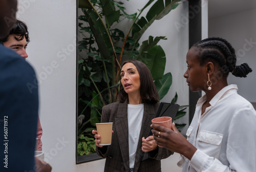 Businesswoman speaking to coworkers during break