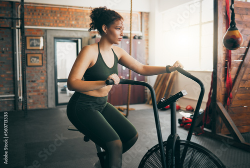 Exercise bike, fitness and woman at gym for workout, cardio training and cycling for energy, balance and lose weight. Sports female or athlete with spinning machine for health, wellness and self care