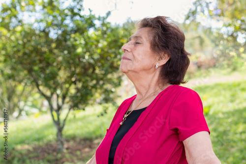 Elderly woman in her 80s enjoying a fresh and healthy morning in the forest, surrounded by greenery