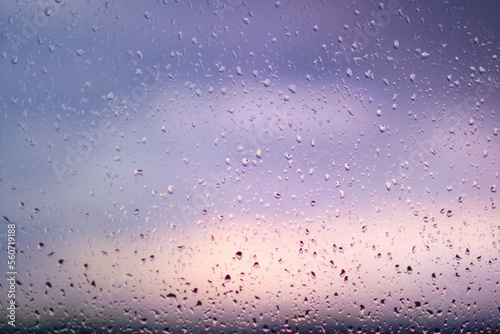 Natural water drops on a window agains a sunset sky.