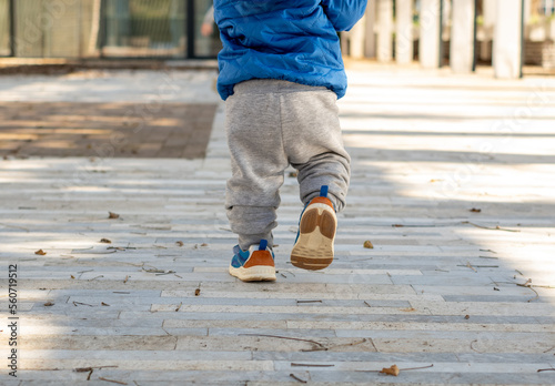 Baby's first steps. Running toddler outdoors. Walking little boy