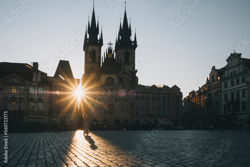 Woman walking at old town square during sunrise, in Prague, Czechia. photo