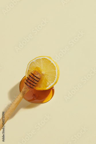 dripping honey on lemons isolated on a light yellow background