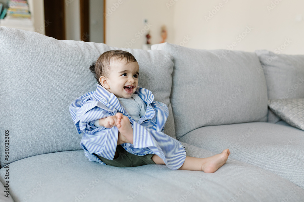 A boy in father's shirt on the couch A boy in father's shirt on the couch