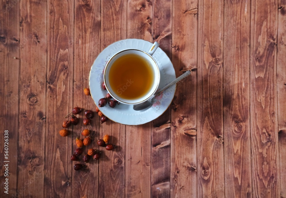 Obraz premium Wooden floor rosehip tea and rosehip herb.