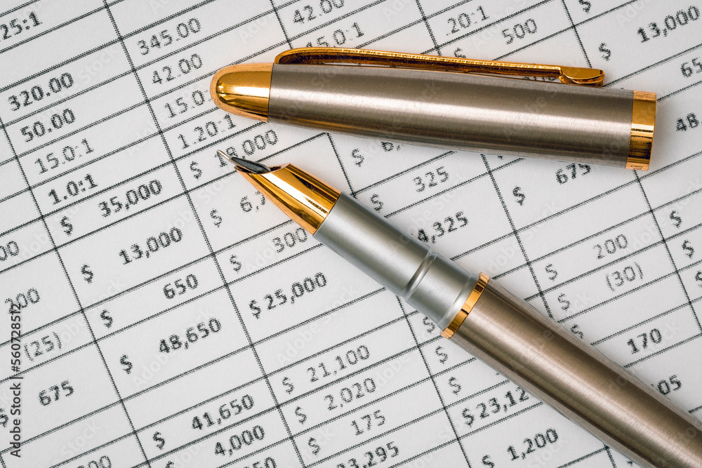 Accounting with pen and financial charts Accounting with pen and financial charts