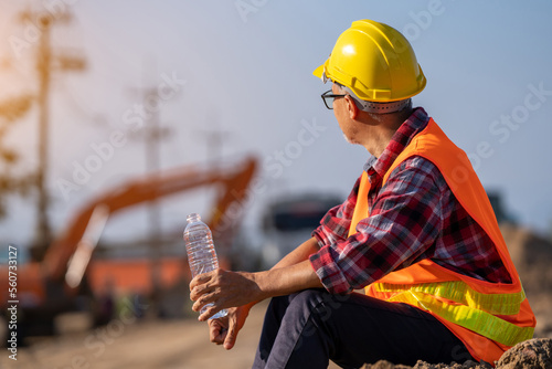 Male engineer takes a break to drink water to relax in the sweltering midday heat.
