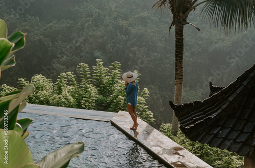 Young travelling girl swimming in the infinity pool in a luxurious home in Ubud, Bali, Indonesia.  © Michal