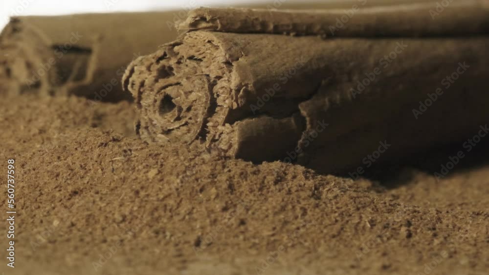 Cinnamom stick falls on Brown cinnamom powder in Slow motion, Macro shot Cinnamom stick falls on Brown cinnamom powder in Slow motion, Macro shot