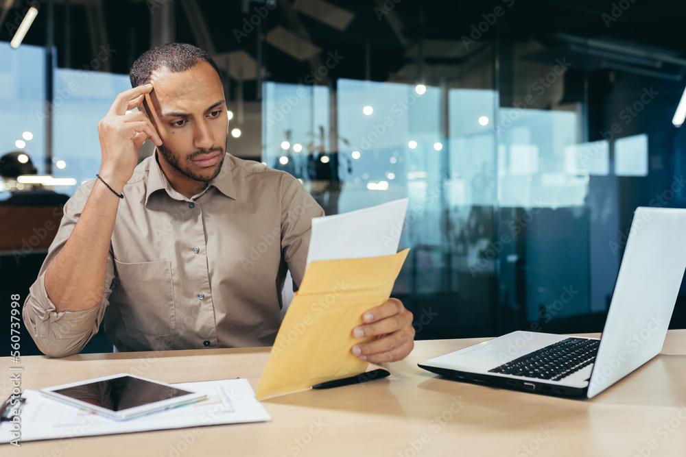 Pensive businessman inside office reading notification letter, man received  envelope thinking about decision sitting at table and laptop inside office,  bad news message. Stock Photo | Adobe Stock