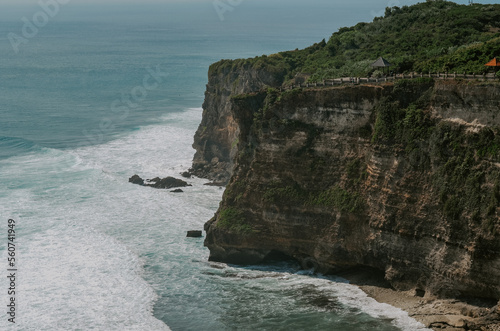 Uluwatu, Bali, Indonesia. A view of dramatic cliffs, coastline, water and waves crashing on a sunny day. 