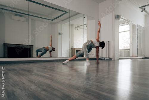 Fototapete ballerina in sportswear trains in front of the mirror