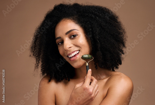 Black woman, beauty and portrait with a facial roller on skin for a massage with a smile, glow and happiness. Face of aesthetic model with afro hair and dermatology cosmetic tool for spa treatment