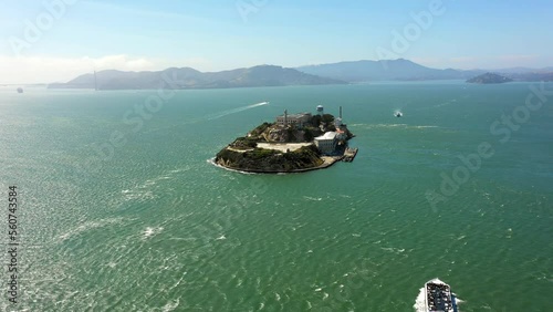 Aerial Panning Shot Of Passenger Ship Moving By Alcatraz Island, Drone Flying Over Ocean On Sunny Day - San Francisco, California