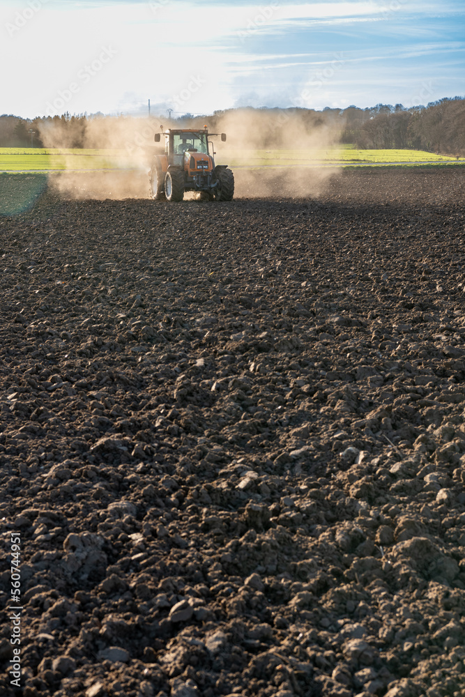 Fototapeta premium Epandage d'engrais Bio3G stimulateur de croissance qui augmente l'activité microbienne du sol sur un champ labouré avant semis
