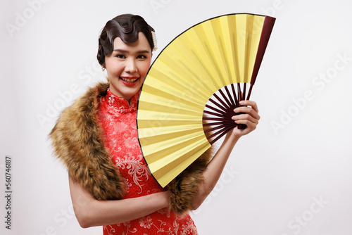 Smiling young beautiful woman holding a golden fan in traditional dress on isolated white background.