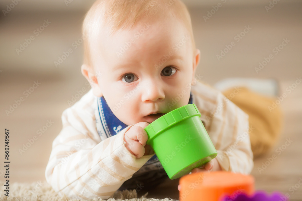 A baby at the age of 8 months learns to crawl at home. Cute little boy crawling on the floor. A baby at the age of 8 months learns to crawl at home. Cute little boy crawling on the floor.