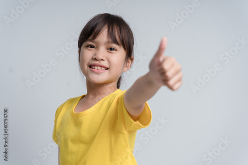 Photo of young little girl happy positive smile show thumb-up like fine recommend ad isolated over white color background