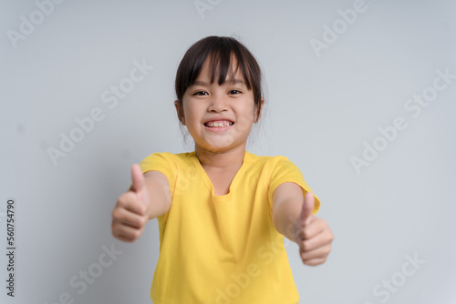 Photo of young little girl happy positive smile show thumb-up like fine recommend ad isolated over white color background