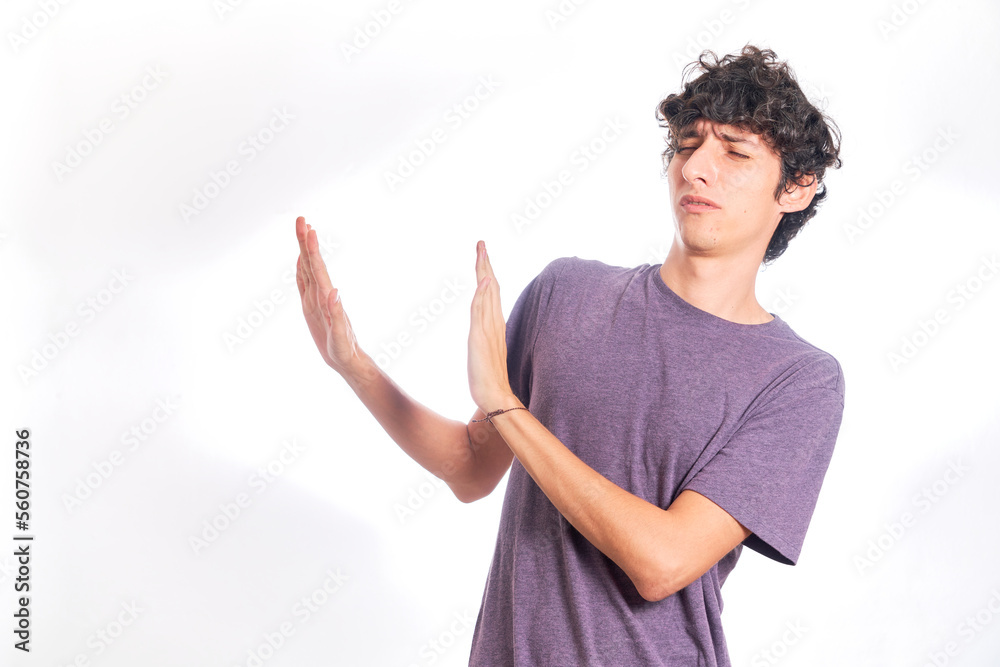 young man rejecting something, on the side of the copy space. Isolated on white background