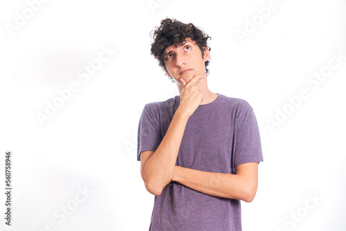 Young Hispanic man thinking looking up. Isolated on white background.