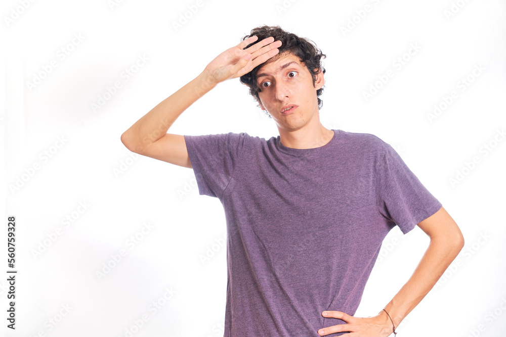 Young Hispanic man making phew gesture. Isolated on white background. Young Hispanic man making phew gesture. Isolated on white background.