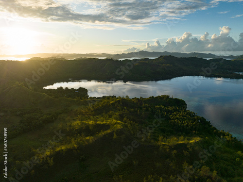 Sunrise illuminates clouds that drift over the calm waters of the Solomon Islands. This scenic region is known for its high marine biodiversity and World War II history.