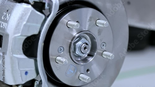 Close up of Brake Disc of the vehicle for repair.Automobile mechanic in process of new tire replacement.Car brake repairing in garage.Car Service and technician concept