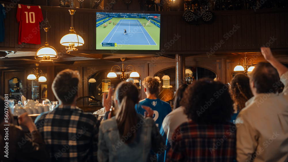 Group of Tennis Fans Watching a Live International Broadcast in a Sports Bar on TV. People Cheering, Supporting Their Player. Crowd Goes Ecstatic When Athlete Scores a Goal and Wins the Championship