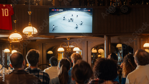 Photography Group of Ice Hockey Fans Watching a Live Match Broadcast in a Sports Pub on TV