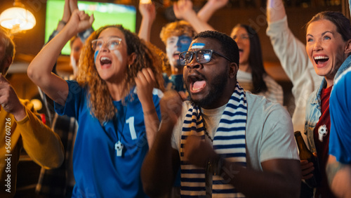 Group of Multiethnic Friends Watching a Live Soccer Match on TV in a Sports Bar. Fans with Painted Faces Cheering. Young People Celebrating When Team Scores a Goal and Wins the Football World Cup.