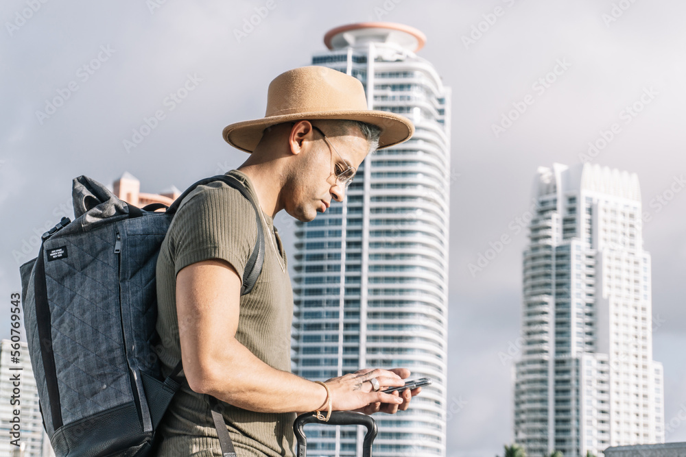 Close up, profile of traveller man with a brown hat, looking for direction on his smartphone. Close up, profile of traveller man with a brown hat, looking for direction on his smartphone.