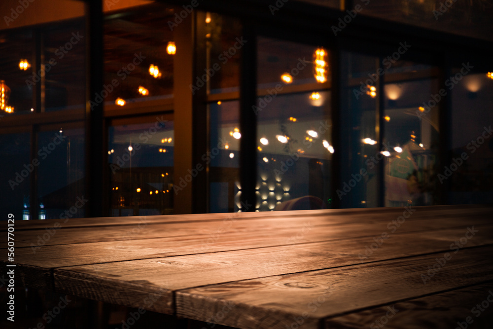 Image of wooden table in front of abstract blurred lights of cafe restaurant Image of wooden table in front of abstract blurred lights of cafe restaurant