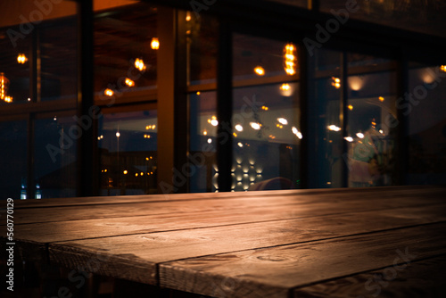 Image of wooden table in front of abstract blurred lights of cafe restaurant