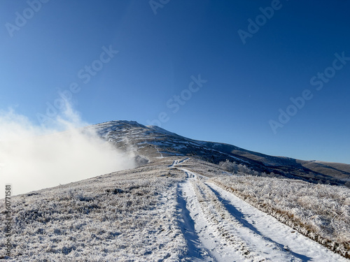 Winter road in the mountains. Above the clouds. Carpathians, Polonynian Beskids, Ukraine.